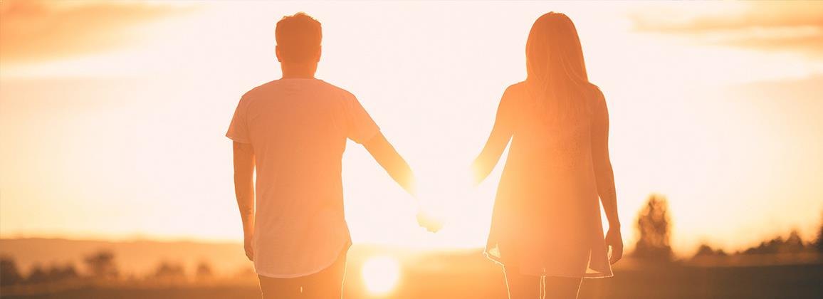 Couple holding hands and watching the sunset after couples counselling session