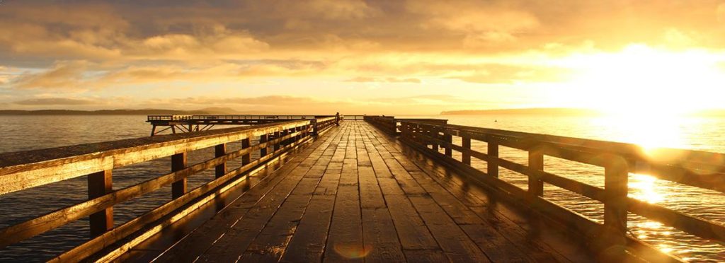 Sun rising over a wooden pier, symbolising a new life direction and a better future